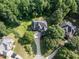 Aerial view of brick home with manicured lawn and landscaping in a wooded area at 230 Paula Dr, Angier, NC 27501