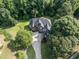 Aerial view of brick home with large backyard and mature trees nestled amongst greenery at 230 Paula Dr, Angier, NC 27501
