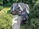 Aerial view of brick home with a long driveway and large backyard surrounded by trees at 230 Paula Dr, Angier, NC 27501