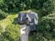 Aerial view of brick home surrounded by mature trees, lush lawn, and landscaping at 230 Paula Dr, Angier, NC 27501