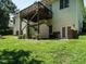 Spacious backyard with lush green grass, wooden deck, storage shed, and walkout basement entrance at 230 Paula Dr, Angier, NC 27501