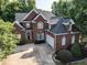 Brick home with white trim, arched windows, side-entry garage, and mature landscaping at 230 Paula Dr, Angier, NC 27501