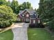 Beautiful brick home features a long driveway, manicured lawn, and mature trees at 230 Paula Dr, Angier, NC 27501