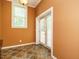 Hallway with bright orange walls, a window, an entry door and decorative tile floors at 230 Paula Dr, Angier, NC 27501