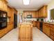 Kitchen with a center island, dark appliances, tile floors and wood cabinets at 230 Paula Dr, Angier, NC 27501
