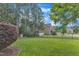 Well manicured backyard with privacy fence, trees, green lawn and playground in the background at 237 Bendemeer Ln, Rolesville, NC 27571