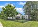 Landscaped backyard with beautiful green lawn, mature trees, black fence and a view of the house at 237 Bendemeer Ln, Rolesville, NC 27571
