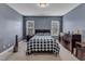 Comfortable bedroom with blue walls, a bed with blue and white checkered pattern and two windows at 237 Bendemeer Ln, Rolesville, NC 27571
