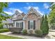 Side view of a well-kept home featuring brick accents, black shutters, and mature landscaping at 237 Bendemeer Ln, Rolesville, NC 27571