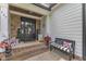 Attractive front door with brick steps, potted flowers, and a cozy bench for a welcoming appeal at 237 Bendemeer Ln, Rolesville, NC 27571