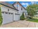 Exterior view of a three car garage with driveway, beautiful green lawn and blue skies at 237 Bendemeer Ln, Rolesville, NC 27571