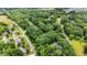 Aerial view showcasing a neighborhood with lush green trees, streets, and scattered homes at 2382 Council Rd, Graham, NC 27253