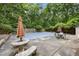 Inviting backyard featuring a covered in-ground pool surrounded by mature trees and patio furniture at 2382 Council Rd, Graham, NC 27253