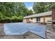 Spacious backyard showing the covered pool, the house, and an outdoor dining set, perfect for relaxing at 2382 Council Rd, Graham, NC 27253