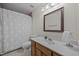 Bathroom featuring a shower-tub combo, patterned tile floor and wood vanity at 2382 Council Rd, Graham, NC 27253