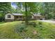 Charming home exterior featuring a lush lawn, mature trees, and a welcoming two-car garage at 2382 Council Rd, Graham, NC 27253