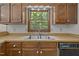 Traditional kitchen featuring wood cabinets, stainless steel sink, and a window overlooking the backyard at 2382 Council Rd, Graham, NC 27253