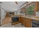 Well-lit kitchen with stainless sink, wooden cabinetry, and views into the living room at 2382 Council Rd, Graham, NC 27253