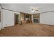 Spacious living room featuring a stone fireplace, ceiling fan, built-in shelving and carpet at 2382 Council Rd, Graham, NC 27253