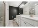 Main bathroom with double sink vanity, framed mirrors, brushed nickel fixtures, and black accent wall at 241 White Oak Ridge Dr, Garner, NC 27529