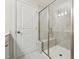 Brightly lit walk-in shower featuring tile surround and frameless glass doors with bench seat at 241 White Oak Ridge Dr, Garner, NC 27529
