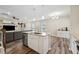 Open-concept kitchen island overlooking the living area, complete with modern appliances and stylish pendant lighting at 241 White Oak Ridge Dr, Garner, NC 27529