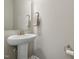 Bright powder room featuring a pedestal sink, decorative mirror, and neutral color scheme at 241 White Oak Ridge Dr, Garner, NC 27529