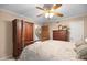 Comfortable bedroom featuring a ceiling fan, a large wardrobe, and neutral color scheme at 2523 Lovette Ln, Graham, NC 27253