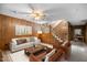 Cozy living room featuring wood paneling, a staircase, and comfortable seating at 2523 Lovette Ln, Graham, NC 27253