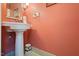 Compact half-bath with pink walls, pedestal sink, and simple decor at 3013 Brassfield Dr, Rocky Mount, NC 27803