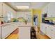 Bright kitchen with white cabinets, wooden floors, breakfast bar, and view to laundry room at 3013 Brassfield Dr, Rocky Mount, NC 27803