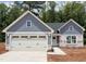 Charming single-story home with a two-car garage, grey siding, and manicured landscaping at 307 Rothbury Ct, Sanford, NC 27330