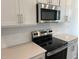 A stainless steel microwave and electric range are the focal point of the kitchen at 3103 White Blossom Ct, Raleigh, NC 27610