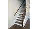 A modern staircase features hardwood treads, a black metal railing, and white risers at 3103 White Blossom Ct, Raleigh, NC 27610