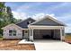 New construction home featuring vertical siding, covered entrance and an attached two-car garage at 318 Rothbury Ct, Sanford, NC 27330
