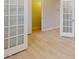 Open living area with light wood flooring and glass paneled doors for a modern aesthetic at 3193 Mission Olive Pl # 351, New Hill, NC 27562