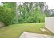 View of the grass backyard with lush trees around the border at 321 Westgrove Ct, Durham, NC 27703