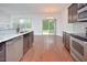 Modern kitchen with stainless steel appliances, granite countertops and dark wood cabinets flows into the dining area at 321 Westgrove Ct, Durham, NC 27703