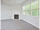 Bright living room features neutral carpeting, a fireplace, and large windows at 321 Westgrove Ct, Durham, NC 27703