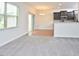 Cozy living area features large window and neutral carpeting flowing into the open-concept kitchen and dining area at 321 Westgrove Ct, Durham, NC 27703