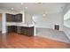 Open-concept living room and kitchen featuring modern stainless steel appliances and a cozy fireplace at 321 Westgrove Ct, Durham, NC 27703