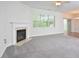 Spacious living room with a fireplace, large windows, and access to the dining area at 321 Westgrove Ct, Durham, NC 27703