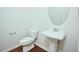Cozy powder room boasts hardwood floors, pedestal sink, and classic fixtures at 321 Westgrove Ct, Durham, NC 27703