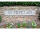 Stone monument sign in a flower bed displaying the community's name, Brier Village at 321 Westgrove Ct, Durham, NC 27703