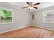 Sunny bedroom with hardwood floors, ceiling fan, and view to backyard at 3216 Idlewood Village Dr, Raleigh, NC 27610
