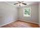 Neutral bedroom with hardwood floors, ceiling fan and a view from the window at 3216 Idlewood Village Dr, Raleigh, NC 27610