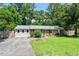 Inviting ranch home featuring a lush front lawn, brick accents, and a vibrant teal-colored front door at 3216 Idlewood Village Dr, Raleigh, NC 27610
