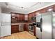 Bright kitchen featuring stainless appliances, track lighting, and brown wooden cabinetry at 3216 Idlewood Village Dr, Raleigh, NC 27610