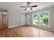 Open living room with hardwood floors, a ceiling fan, and natural light streaming through the windows at 3216 Idlewood Village Dr, Raleigh, NC 27610