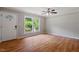 Bright living room with hardwood floors, a large window overlooking greenery, and a white front door at 3216 Idlewood Village Dr, Raleigh, NC 27610